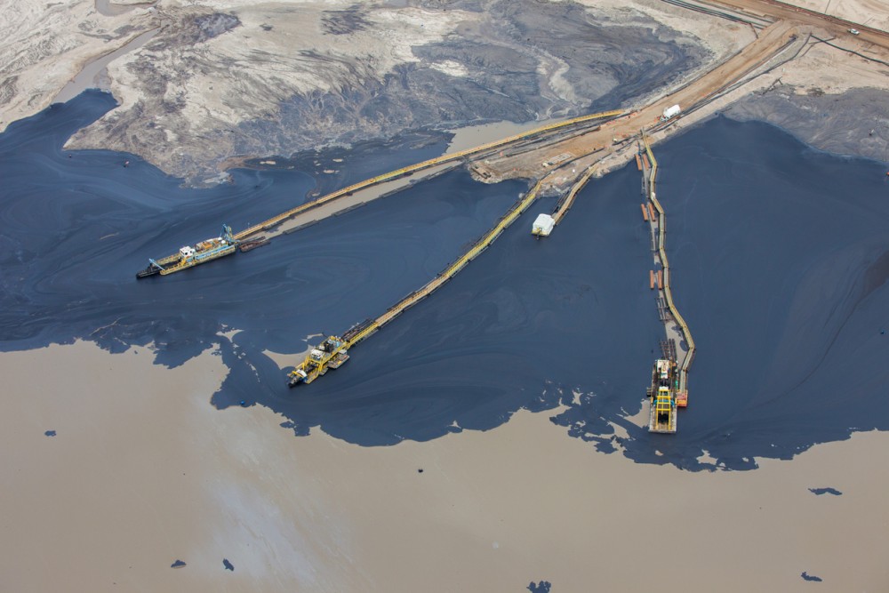 Oilsands tailing pond showing oil being separated from sand