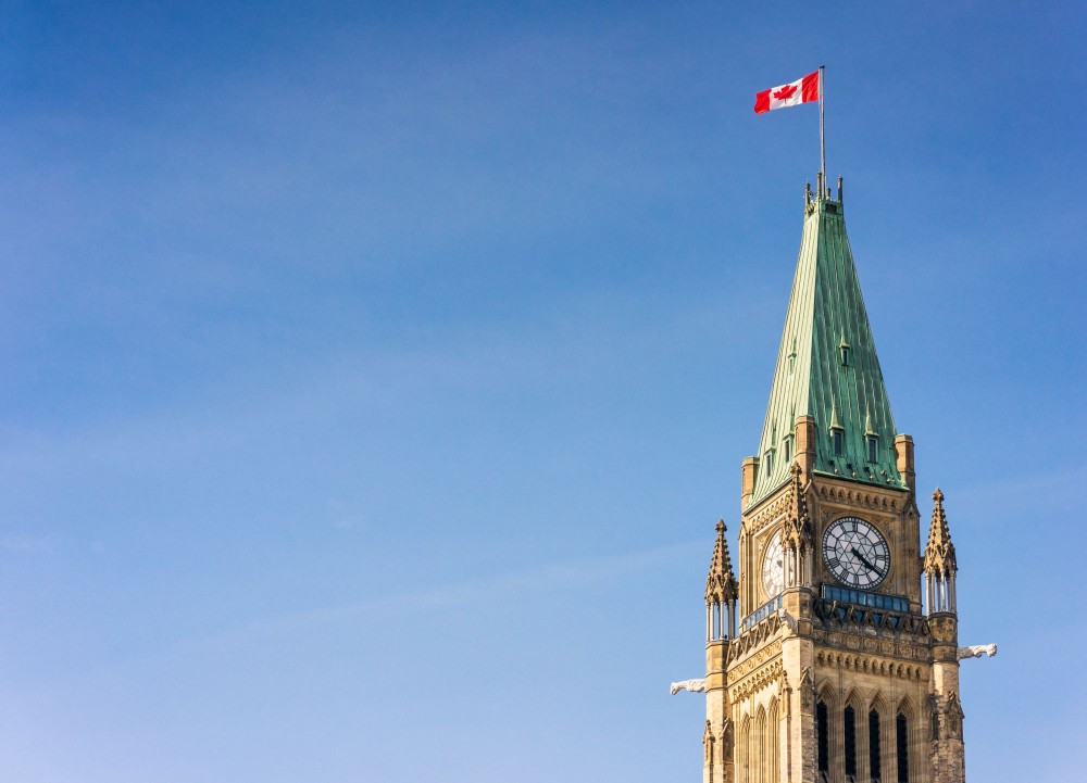 A Canadian flag flying on the top of the Peace Tower, part of the Canadian Parliament Building in Ottawa.