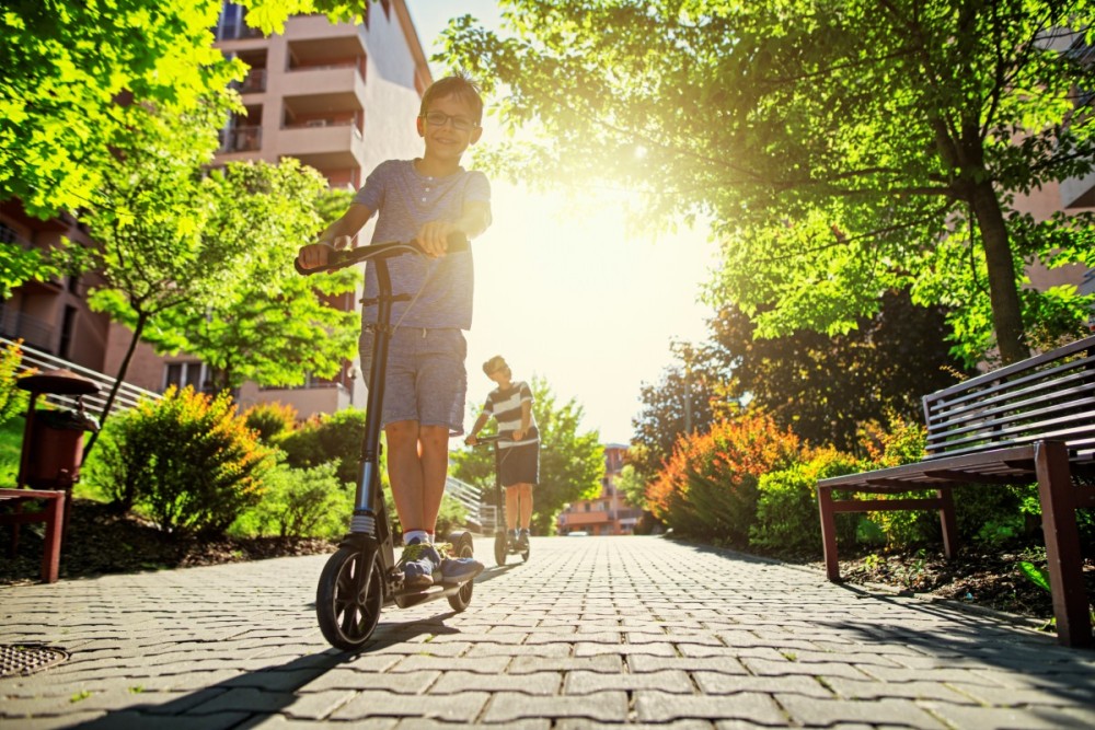 Kids on scooters near apartment buildings