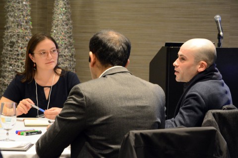 Three policymakers sit around a conference room table 