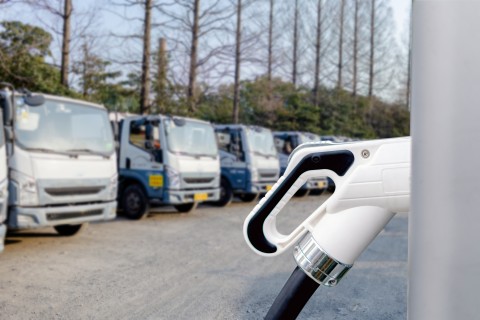 Close up of electric plug on car charging equipment, electric van being charged