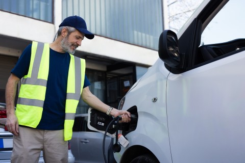 Mature man charging his electric truck at the charging station